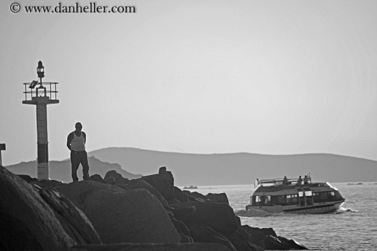 man-on-rocks-watching-boat-bw.jpg