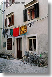 bicycles, clothes, cobblestones, europe, hangings, laundry, pirano, slovenia, vertical, windows, photograph